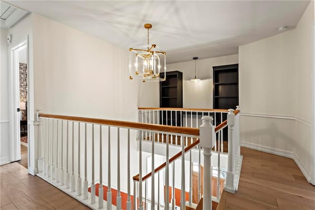 hall featuring hardwood / wood-style flooring and a chandelier