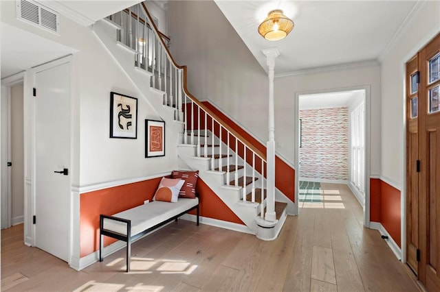 entryway with crown molding, light hardwood / wood-style flooring, and plenty of natural light