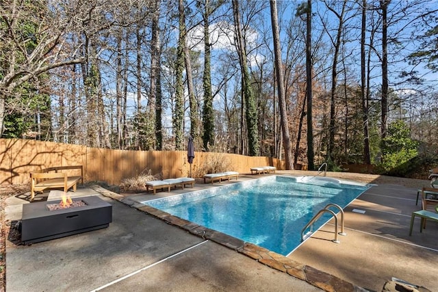 view of pool featuring a diving board, a patio area, and a fire pit