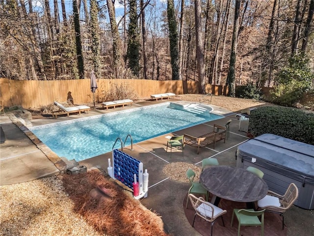 view of pool with a patio and a diving board