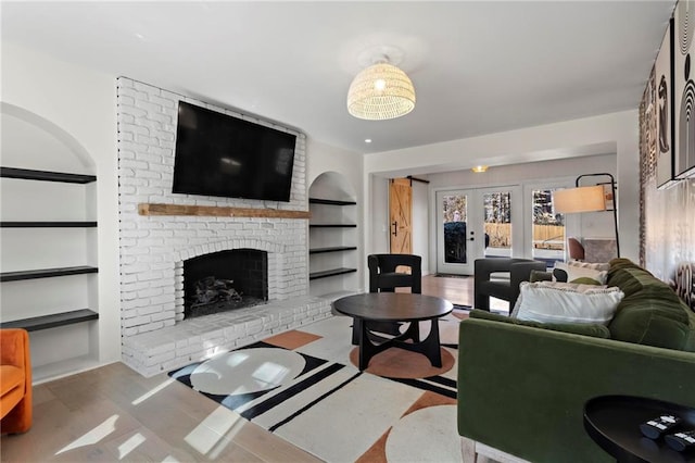 living room with french doors, a fireplace, and built in shelves