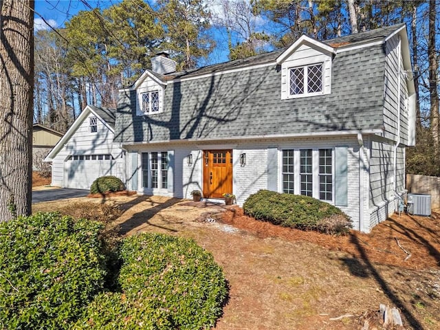 view of front of house with a garage and central air condition unit