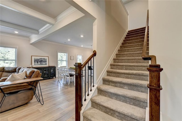 stairs with crown molding, beamed ceiling, and hardwood / wood-style flooring