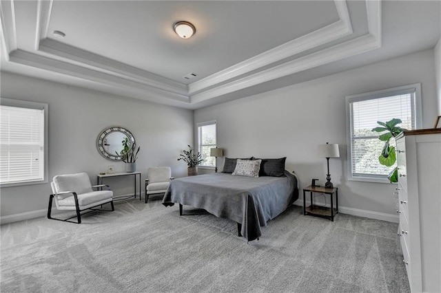 bedroom with a tray ceiling, light carpet, and ornamental molding