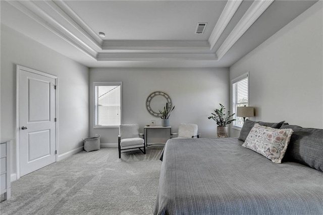 carpeted bedroom featuring a tray ceiling, ornamental molding, and multiple windows