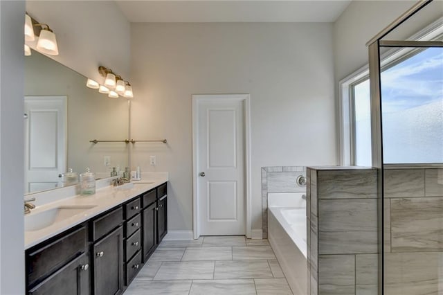 bathroom with tiled tub and vanity