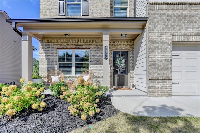 view of exterior entry featuring a garage and a porch