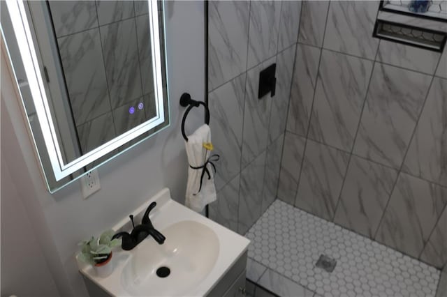 bathroom featuring a tile shower and vanity