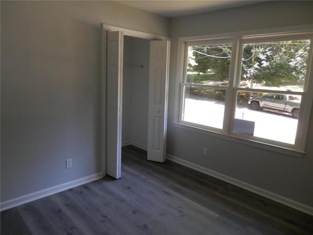 unfurnished bedroom featuring a closet and dark hardwood / wood-style floors