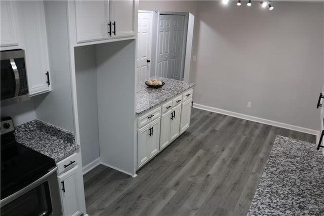 kitchen with appliances with stainless steel finishes, dark hardwood / wood-style flooring, stone countertops, and white cabinets