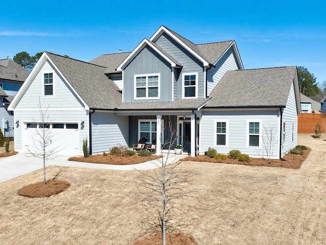 view of front of home with a porch, an attached garage, fence, concrete driveway, and board and batten siding