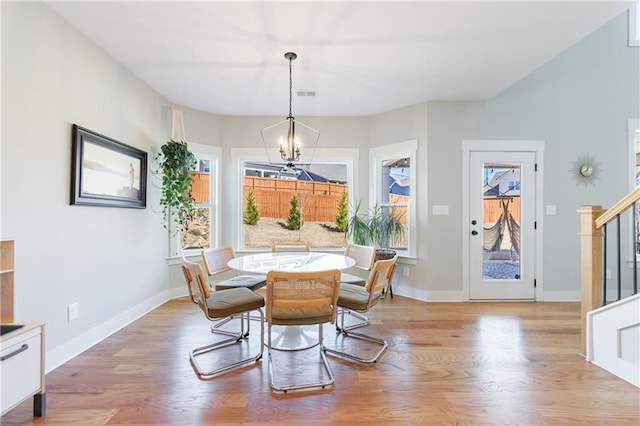 dining room with a notable chandelier, visible vents, baseboards, stairs, and light wood-type flooring