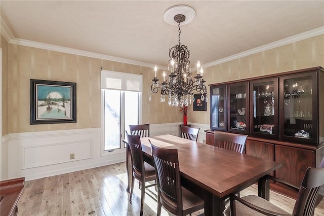 dining space with a chandelier, ornamental molding, and light hardwood / wood-style flooring