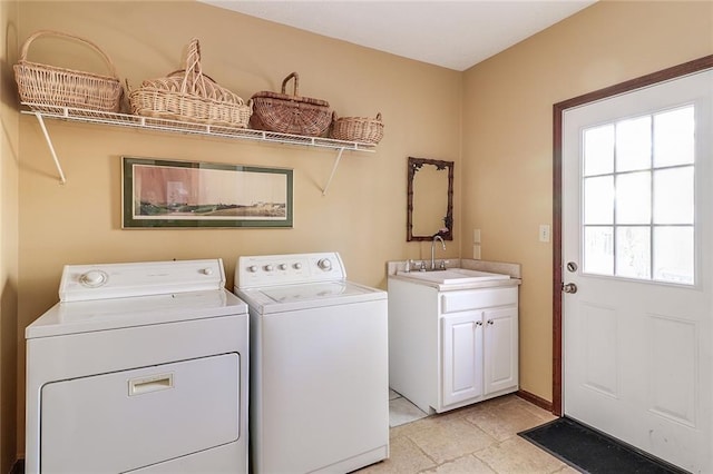 clothes washing area featuring cabinets, washing machine and dryer, and sink