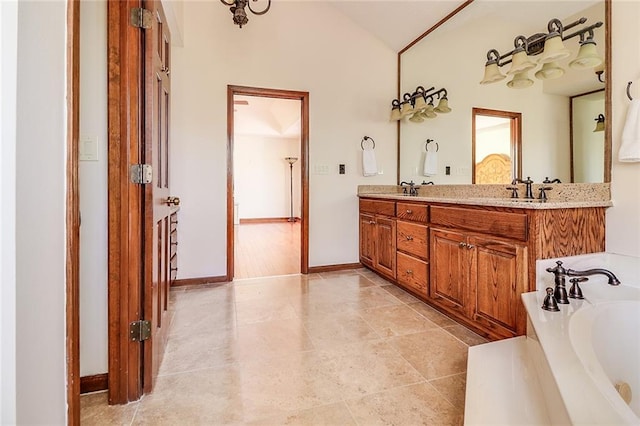 bathroom featuring a bathtub, vanity, and lofted ceiling