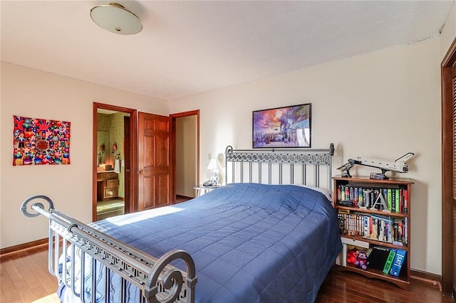 bedroom featuring hardwood / wood-style floors and ensuite bathroom