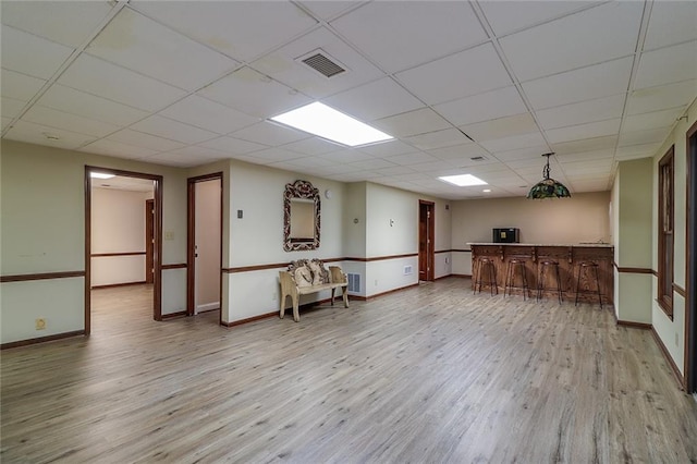 interior space featuring light wood-type flooring and a drop ceiling