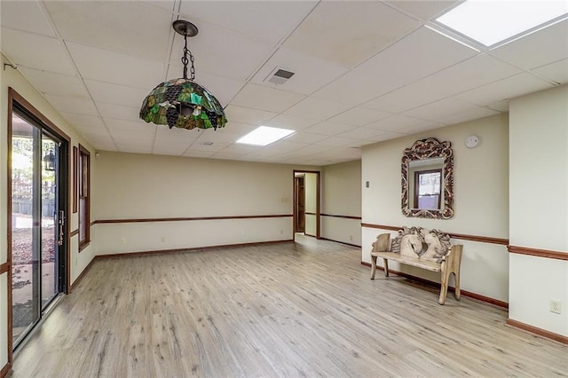 unfurnished room featuring a paneled ceiling and light hardwood / wood-style flooring