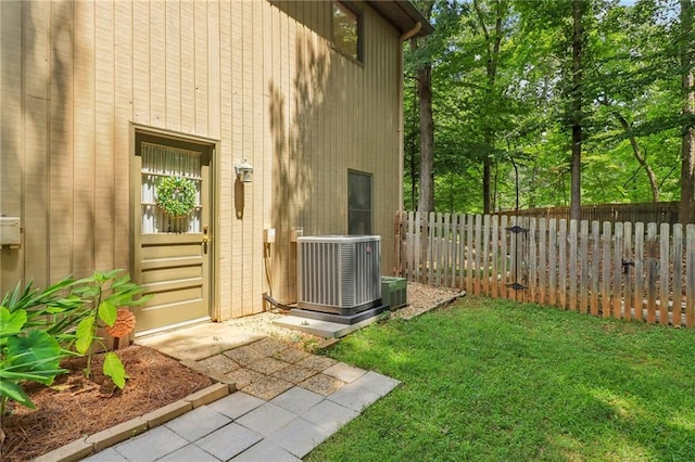 property entrance featuring a yard and cooling unit