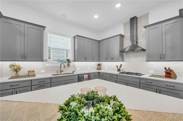 kitchen featuring stainless steel appliances, sink, wall chimney range hood, and gray cabinetry