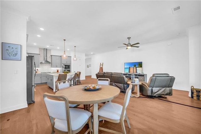 dining room with light hardwood / wood-style flooring and ceiling fan