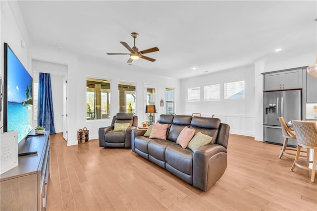 living room featuring ceiling fan and light hardwood / wood-style floors