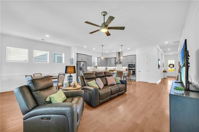 living room featuring ceiling fan and light hardwood / wood-style flooring