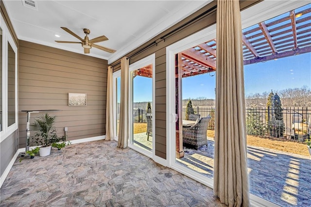 unfurnished sunroom featuring ceiling fan