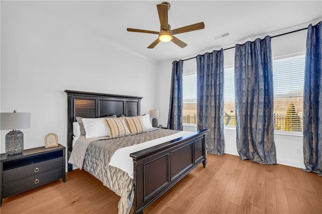 bedroom with ceiling fan, multiple windows, and light wood-type flooring