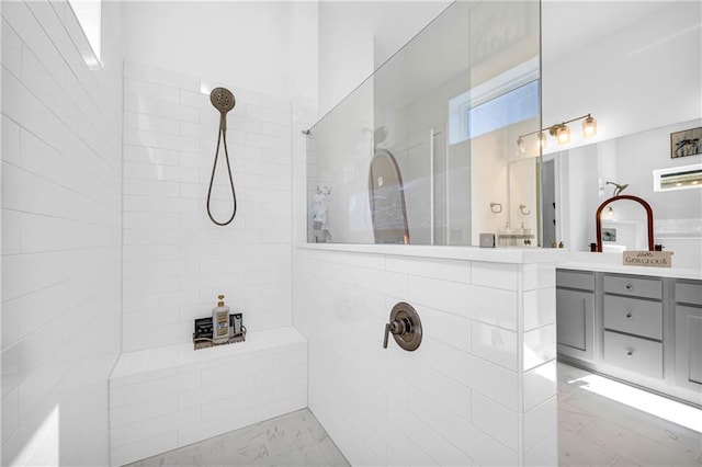 bathroom with vanity and tiled shower