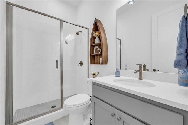 bathroom featuring vanity, toilet, and walk in shower