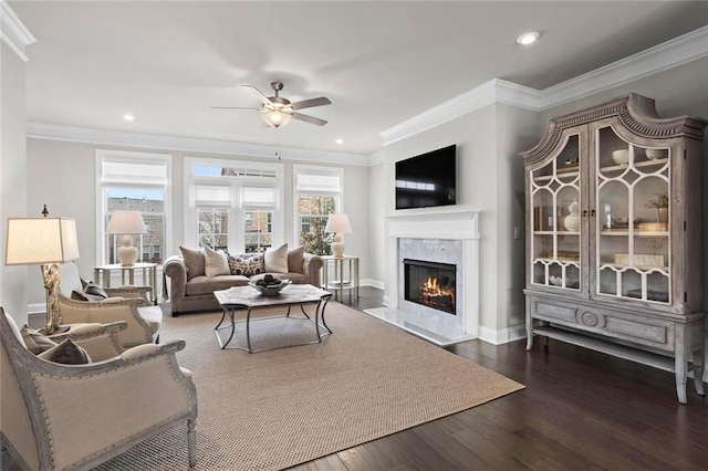 living room with a fireplace, crown molding, recessed lighting, a ceiling fan, and wood finished floors