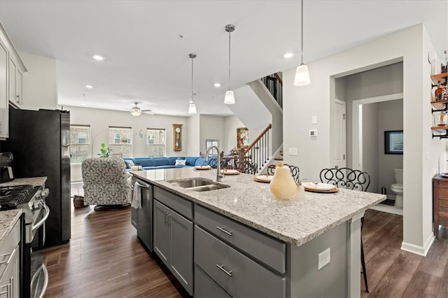 kitchen featuring sink, gray cabinets, an island with sink, and appliances with stainless steel finishes