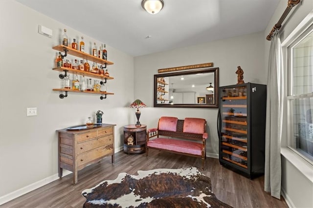 living area with dark wood-type flooring, bar area, and wine cooler