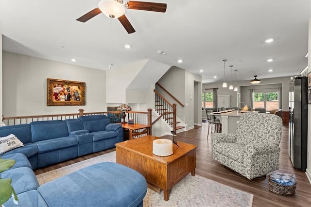 living room with dark hardwood / wood-style flooring and ceiling fan