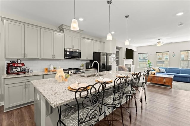 kitchen with a breakfast bar, appliances with stainless steel finishes, gray cabinets, and sink