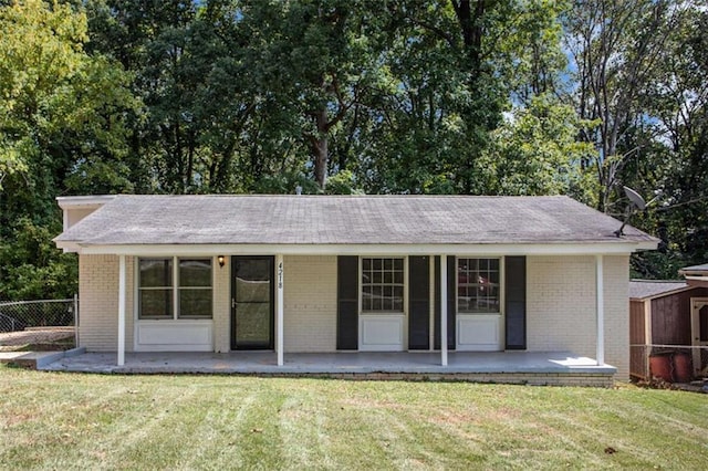 back of house with covered porch and a yard