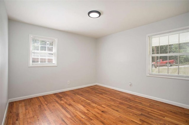 empty room featuring a wealth of natural light and hardwood / wood-style flooring