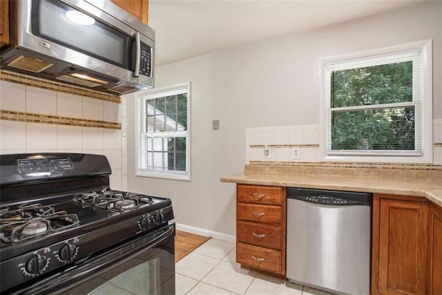 kitchen with light tile patterned floors and stainless steel appliances