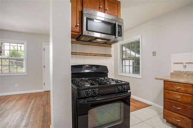 kitchen featuring black gas range oven and light tile patterned floors