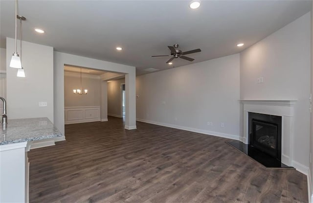 unfurnished living room with a ceiling fan, a glass covered fireplace, dark wood-style flooring, and recessed lighting