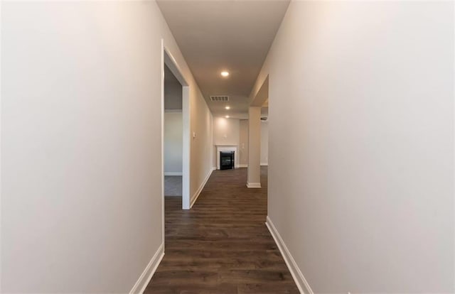 corridor with dark wood-style floors, recessed lighting, visible vents, and baseboards