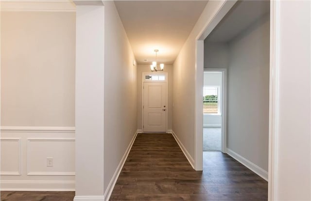 hall with baseboards and dark wood-type flooring