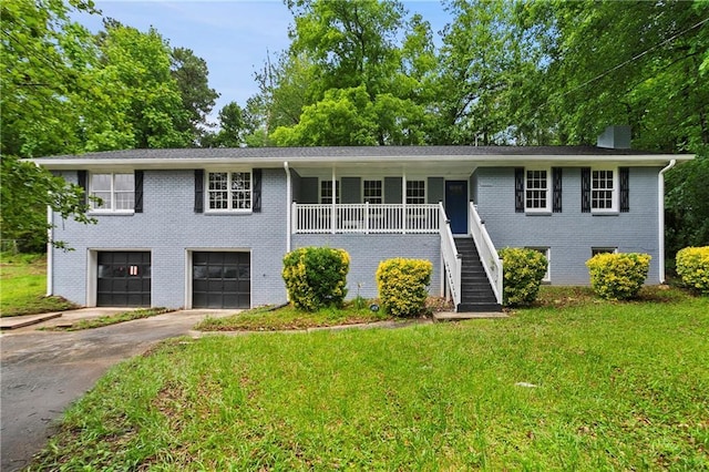 split foyer home with brick siding, driveway, stairway, an attached garage, and a front lawn