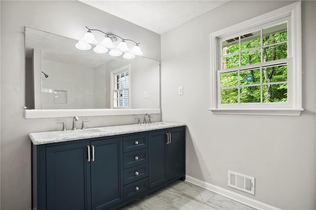 full bathroom featuring marble look tiles, baseboards, and double vanity