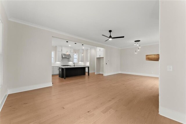 1419 Coretta Bnd, Atlanta, GA 30318 - unfurnished living room featuring ornamental molding, ceiling fan, baseboards, light wood-type flooring, and a sink