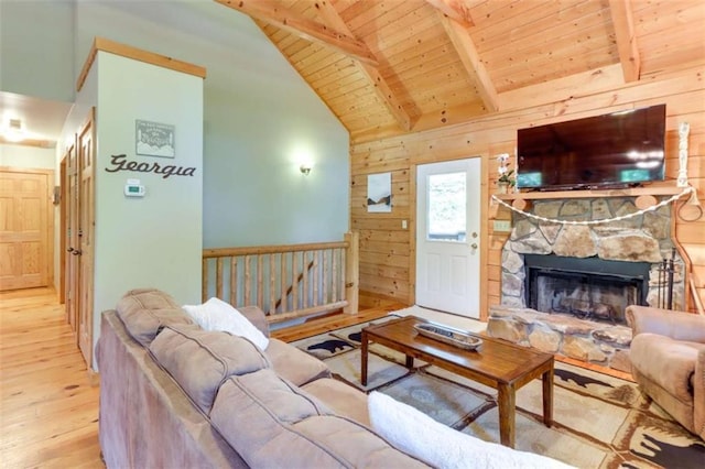 living area with beamed ceiling, a fireplace, wooden ceiling, and wood finished floors