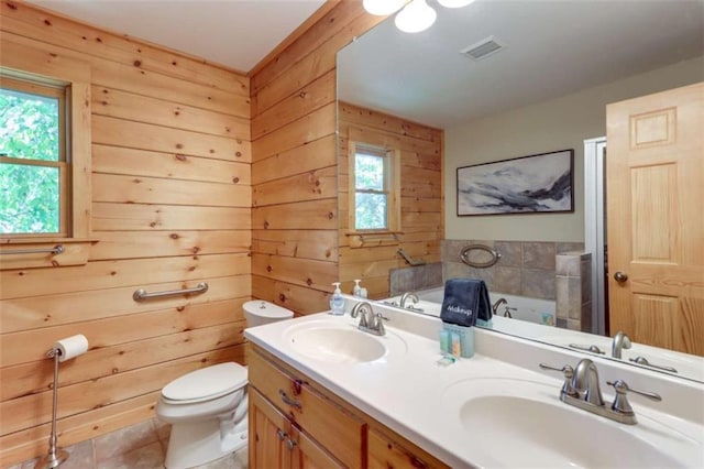 bathroom with toilet, wooden walls, a sink, and a bath