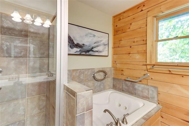 bathroom with a jetted tub, wooden walls, and a shower stall