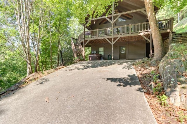 view of front of home with driveway, stairway, and a wooden deck